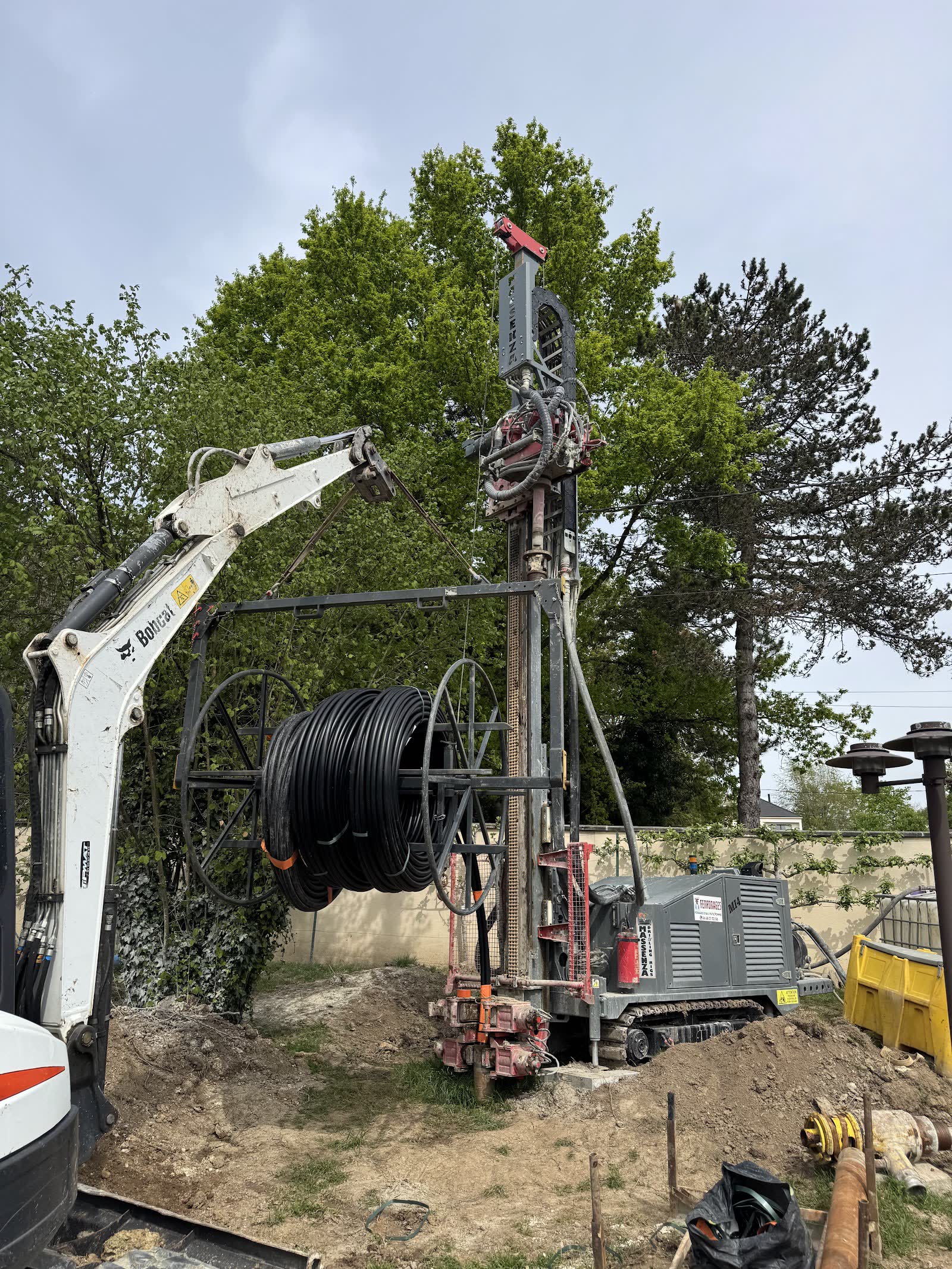 Sondeuse de forage géothermique en action sur un chantier F.F.G, avec bobine de tube PE